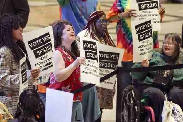 Activists rally with signs advocating for stronger accommodation rights for disabled individuals in Minnesota.